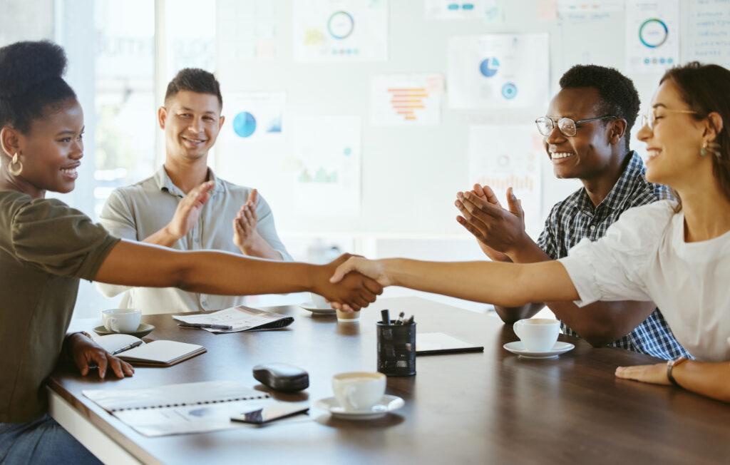 Team members shaking hands, highlighting a strong customer acquisition strategy in action.